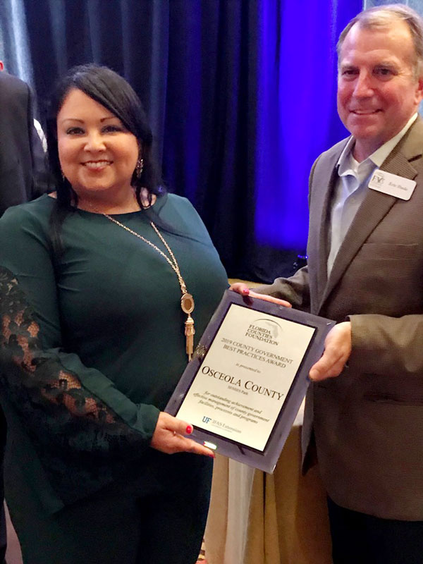 District 2 commissioner Viviana Janer accepts the Best Practice Award from the Florida Association of Counties Thursday night.