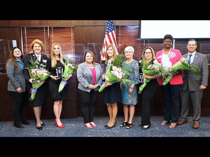 (Left to right): Commissioner Peggy Choudhry, Jessie Chapman, Bethzaida Garcia, Commissioner Viviana Janer, Wilda Belisle, Commissioner Cheryl Grieb, Diana Marrero-Pinto,  Jennifer Paul and Commissioner Ricky Booth.