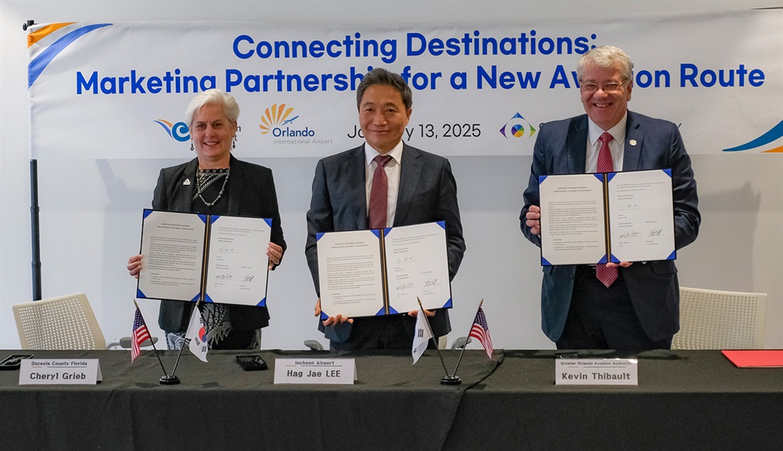 Osceola County Commissioner Cheryl Grieb, Lee Hag-jae, President & CEO of Incheon International Airport and Kevin J. Thibault, CEO of GOAA (l-r) display signed copies of the agreement Monday at NeoCity.