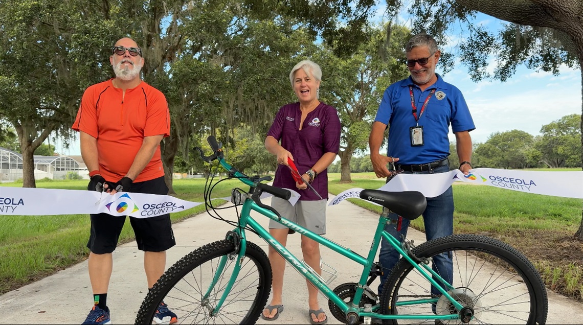 County Commissioner Cheryl Grieb (D4) (center) officially cuts the ribbon on the newest segment, the Kissimmee-St. Cloud Connector Trail, of the County's 200-mile Master Trail Network Plan in St. Cloud.