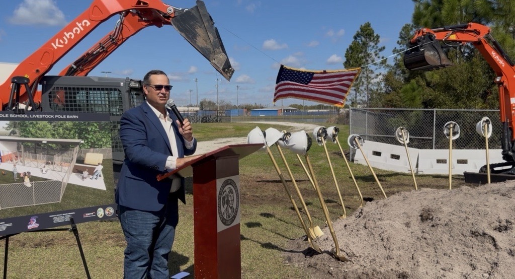 Commissioner Ricky Booth addresses the crowd in attendance for the groundbreaking of the Harmony Middle School pole barn.