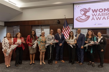 Commissioner Viviana Janer and Margarita Soto (L), Christina Morris and Vice Chairwoman Cheryl Grieb (2nd to L), Nicole DeGennaro and Chairman Brandon Arrington (C), Kelly Trace and Commissioner Ricky Booth (2nd to R), and Bettina Grzeskowiak and Commissioner Peggy Choudhry at the Woman Warrior Ceremony.