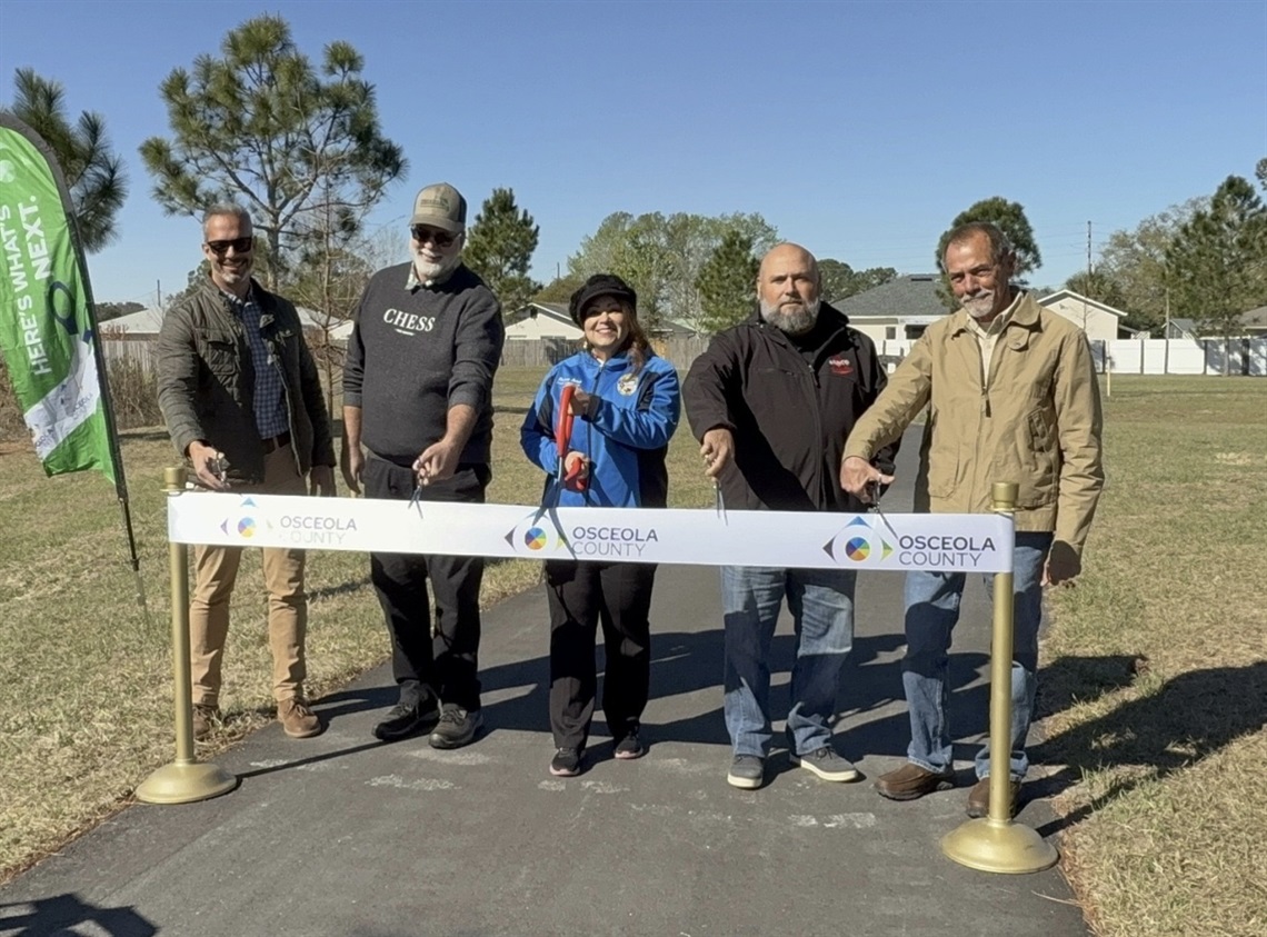 Commissioner Viviana Janer, Arnco Construction and County Staff cut the ribbon at the new Walking Trail at 65th Infantry Veterans Park in Buenaventura Lakes