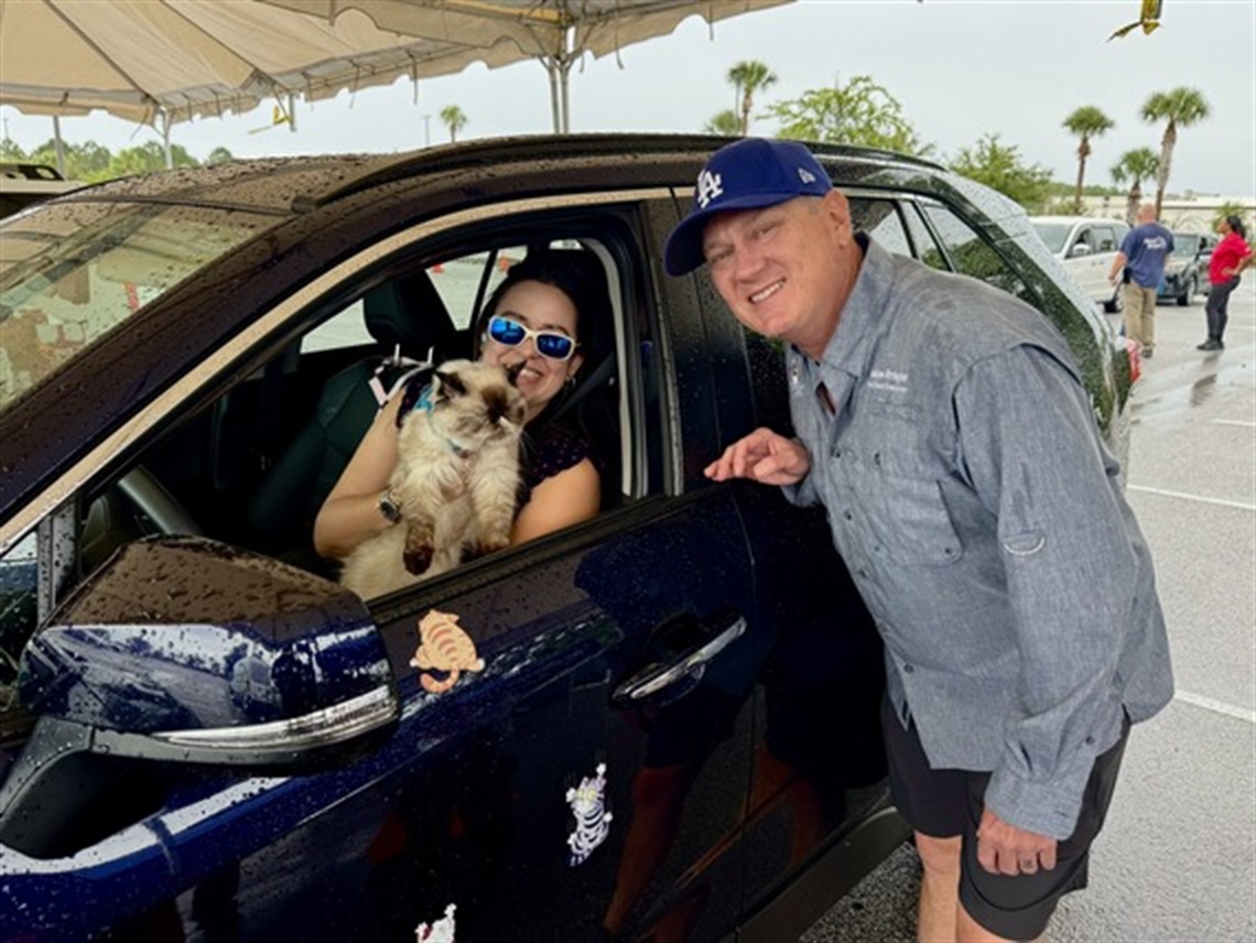 Osceola County District 3 Commissioner & Vice Chairman Brandon Arrington (R) greets a resident and her cat as they participate in the free microchipping event on Saturday, May 31 at Valencia College's Poinciana campus.